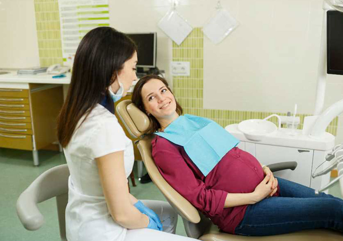Pregnant woman talking to dentist